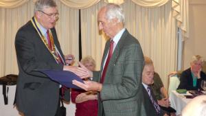 Rotarian George Brown receives his Paul Harris Award from President Martyn Jenkins.